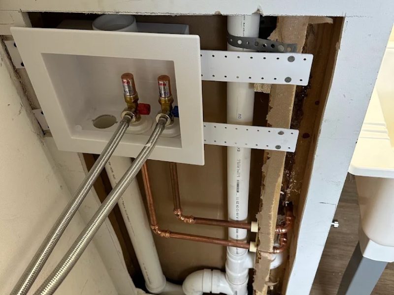 Licensed plumber from Plumbing Pilots inspecting a leak under a kitchen sink in Valparaiso Indiana.